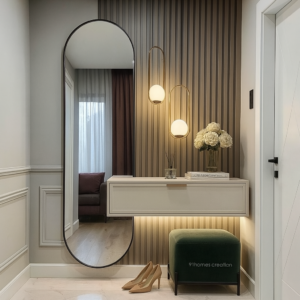 Elegant taupe-wall foyer with oval mirror and pendant lighting