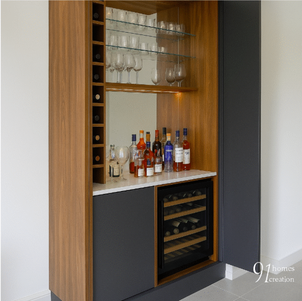 Built-in bar cabinet featuring wine rack, liquor display, and glass holders